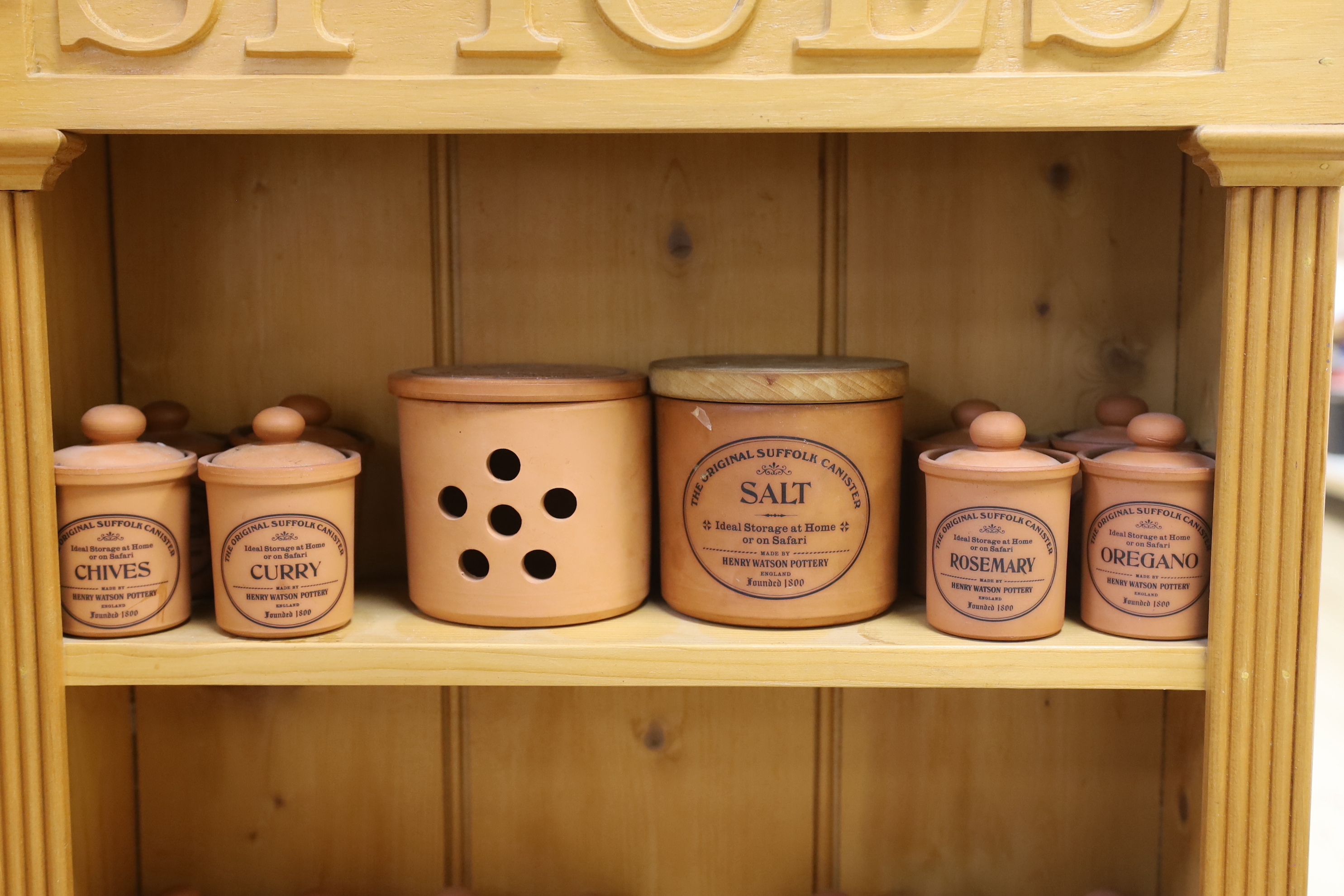 A pine kitchen spice rack with Henry Watson Pottery ‘Original Suffolk Canister’ set